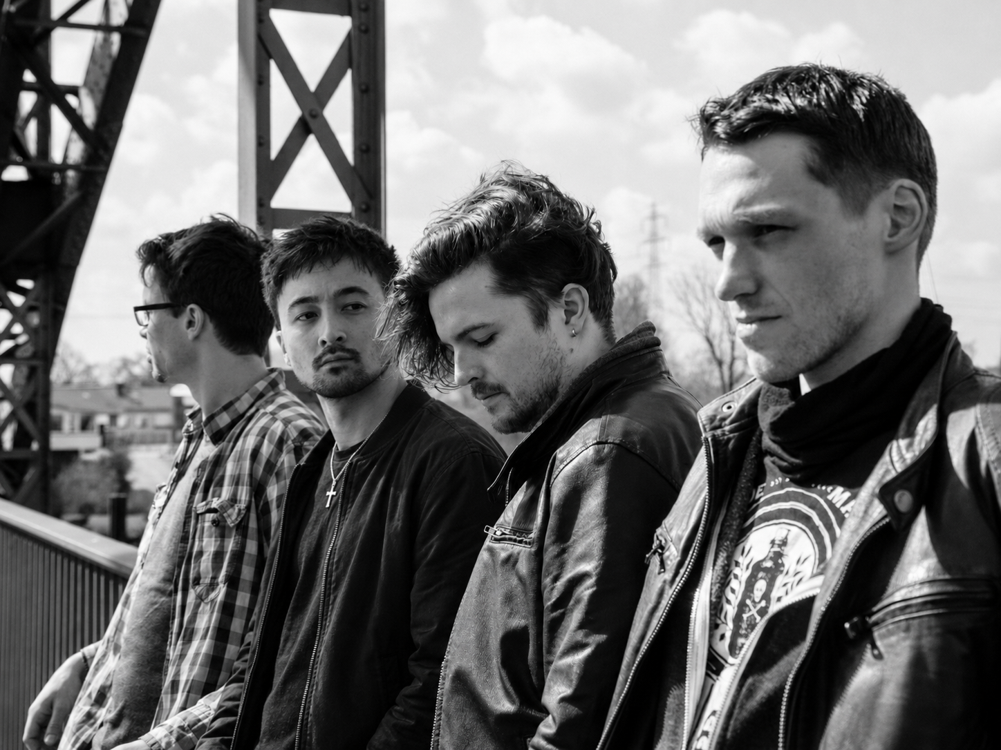 Die vier aktuellen Mitglieder von Falke Collective gemeinsam auf einer Stahlbrücke, fotografiert in Schwarz-Weiß.